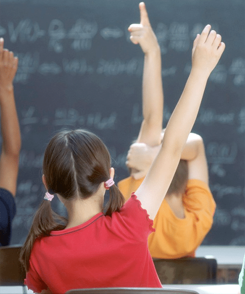 kids in class with hands up